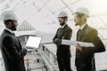 Engineering indian men with paper and hardhat working indoors in building . Team of architects working together on business plan. Royalty Free Stock Photo