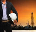 engineering man and safety helmet standing against beautiful dusky sky of oil refinery plant scene use for energy of fossil fuel Royalty Free Stock Photo