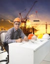 engineering man with safety helmet working table against building construction background Royalty Free Stock Photo