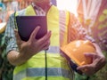 Engineering man standing with yellow safety helmet and holding tablet, work concept Royalty Free Stock Photo