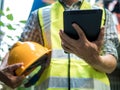 Engineering man standing with yellow safety helmet and holding tablet, work concept Royalty Free Stock Photo