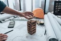 Engineering play. Blocks wood tower game jenga on blueprint factory, industry layout. Engineer and architect concept Royalty Free Stock Photo