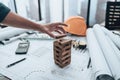 Engineering play. Blocks wood tower game (jenga) on blueprint factory, industry layout. Engineer and architect concept Royalty Free Stock Photo