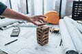 Engineering play. Blocks wood tower game (jenga) on blueprint factory, industry layout. Engineer and architect concept Royalty Free Stock Photo