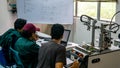 Engineering students discussing and solving the task given on the automation machine system in the laboratory