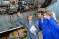 Engineering teacher checking airplane engines with students