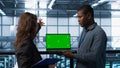 Engineers in data center using green screen laptop, reviewing equipment health