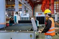 Engineering technician worker is operating the machine inside factory using touch screen computer monitor to command the order for Royalty Free Stock Photo