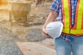 Engineering woman holding a white safety helmet standing In front of the construction site. Concepts for controlling and checking Royalty Free Stock Photo