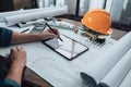 Engineering working with drawings inspection on tablet in the office and Calculator, triangle ruler, safety glasses, compass,