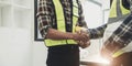 Engineers or architecture shaking hands at construction site for architectural project, holding safety helmet on their Royalty Free Stock Photo