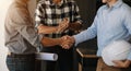 Engineers or architecture shaking hands at construction site for architectural project, holding safety helmet on their hands. Royalty Free Stock Photo