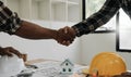 Engineers or architecture shaking hands at construction site for architectural project, holding safety helmet on their Royalty Free Stock Photo