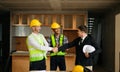 Engineers or architecture shaking hands at construction site for architectural project, holding safety helmet on their hands. Royalty Free Stock Photo