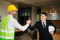 Engineers or architecture shaking hands at construction site for architectural project, holding safety helmet on their hands. Royalty Free Stock Photo