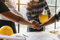 Engineers or architecture shaking hands at construction site for architectural project, holding safety helmet on their hands. Royalty Free Stock Photo