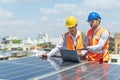 Engineers discussing project of solar power station. Solar panel technician on roof. Engineer and Young technician installing Royalty Free Stock Photo