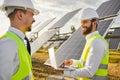 Engineers discussing solar power project and monitoring work on laptop