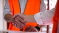 Construction worker in protective uniform shaking hands at construction site Royalty Free Stock Photo