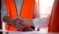 Construction worker in protective uniform shaking hands at construction site Royalty Free Stock Photo