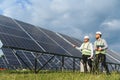 Engineers inspecting solar panel installation for clean energy development Royalty Free Stock Photo