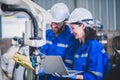 Two engineers mechanic using computer controller Robotic arm for welding steel in steel factory workshop. Industry robot