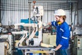 Engineers mechanic using computer controller Robotic arm for welding steel in steel factory workshop. Industry robot programming