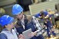 Engineers in metallurgic factory working on digital tablet