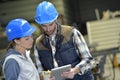 Engineers in metallurgic factory working on digital tablet