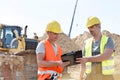 Engineers reading clipboard at construction site against clear sky Royalty Free Stock Photo