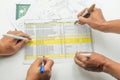Engineer team assesses bill of material with detailed documentation and collaborative effort