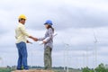 Engineers stand holding blueprints and congratulate wind turbine projects to generate electricity and check wind direction Royalty Free Stock Photo