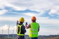 The engineers standing outdoor survey wind turbines green energy