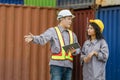 Engineers with tablet managing cargo operations, Engineer and foreman dock worker checking containers box at shipping yard Royalty Free Stock Photo