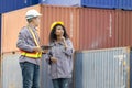 Engineers with tablet managing cargo operations, Engineer and foreman worker checking containers box at shipping yard Royalty Free Stock Photo