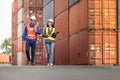 Engineers team managing cargo operations, Foreman dock workers checking containers box at shipping yard Royalty Free Stock Photo