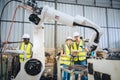 Engineers team mechanic using computer controller Robotic arm for welding steel in steel factory workshop. Industry robot Royalty Free Stock Photo