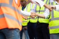 Engineers team shaking hands are congratulated on success of the work. Finishing successful meeting