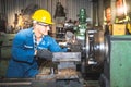 technicians man are working by controlling steel lathes, in parts production line at workplace