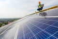 Engineers use a laptop computer to examine the solar panels on the roof of a house where the solar panels are installed using