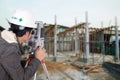 Engineers use tacheometer or theodolite with building construction site Royalty Free Stock Photo