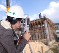 Engineers use tacheometer or theodolite with building construction site Royalty Free Stock Photo