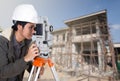 Engineers use tacheometer or theodolite with building construction site Royalty Free Stock Photo