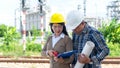 Engineers woman and supervisor man holding blueprint and discussion report schedule for workers security Royalty Free Stock Photo