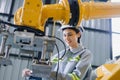 Engineers woman using wrench maintenance robotic arm. Female technician industrial checking robot machine. Futuristic industry