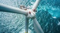 Engineers work on top of wind turbine in sea, aerial view, workers perform maintenance of windmill in ocean at sunset. Concept of Royalty Free Stock Photo