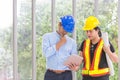 Engineers working meeting room with a tablet. Two workers are watching construction plan. at the office. Electricians carpenter or