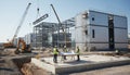 Engineers working on modern construction site with cranes and steel structures planning industrial building project Royalty Free Stock Photo