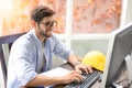 Engineers working within an office using a computer.