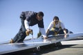 Engineers Working On Solar Panels Against Sky